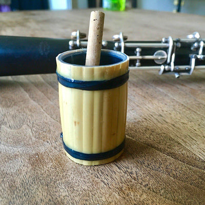 handmade oboe or bassoon reed soaker with an oboe reed and oboe in background