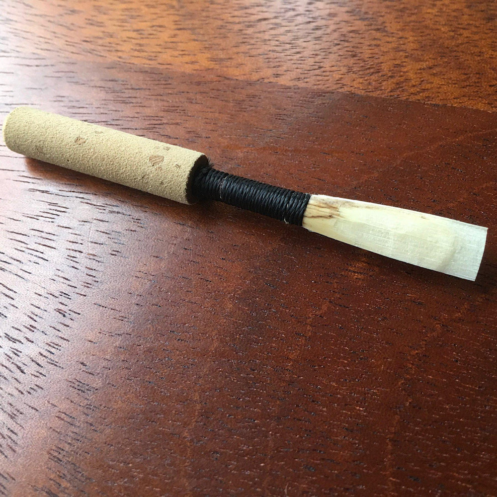 Student oboe reed made by Aaron Lakota to provide the best results, black thread with synthetic cork